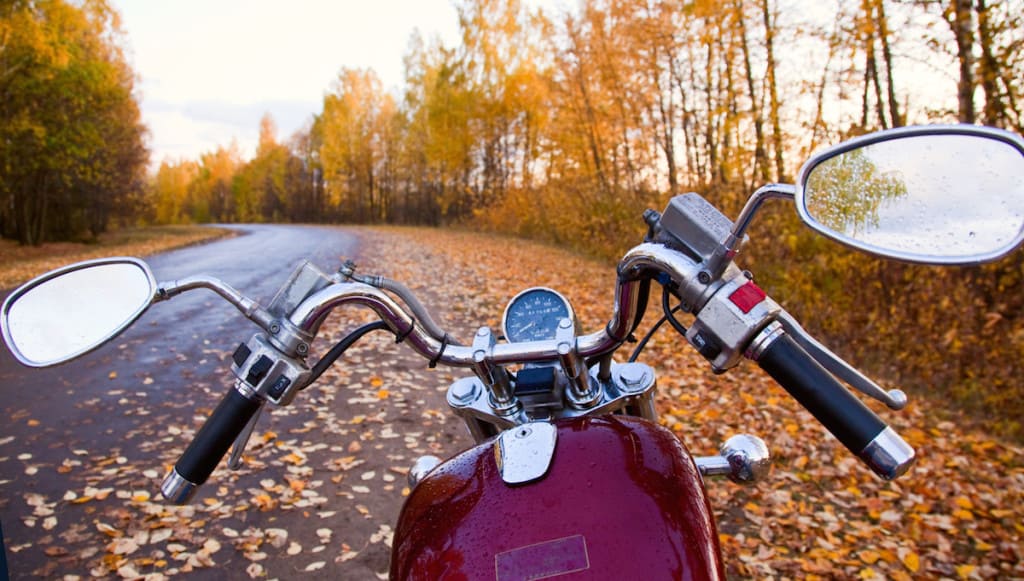 Moto in autunno tra boschi e foglie colorate, avventura e energia sostenibile.