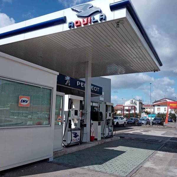 Aquila Energie stazione di rifornimento carburante con pompe e insegna Peugeot.