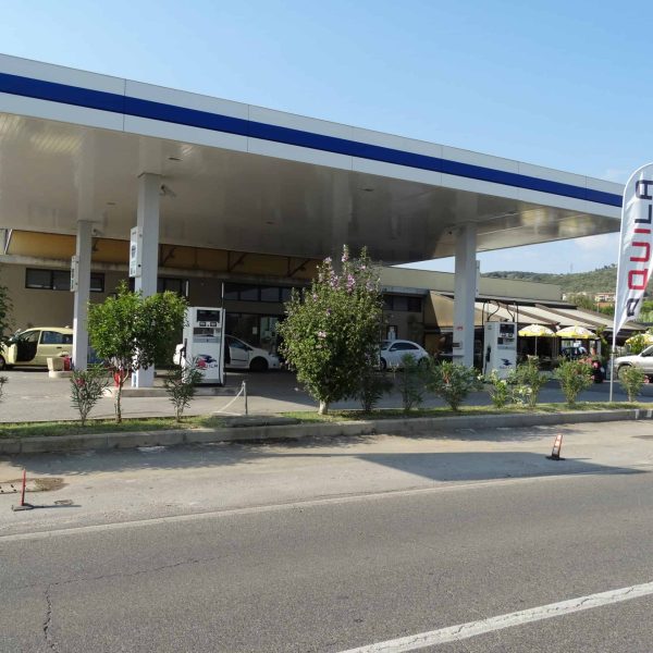 Agenzia di energia Aquila Energie con stazione di rifornimento carburante e veicoli in servizio.
