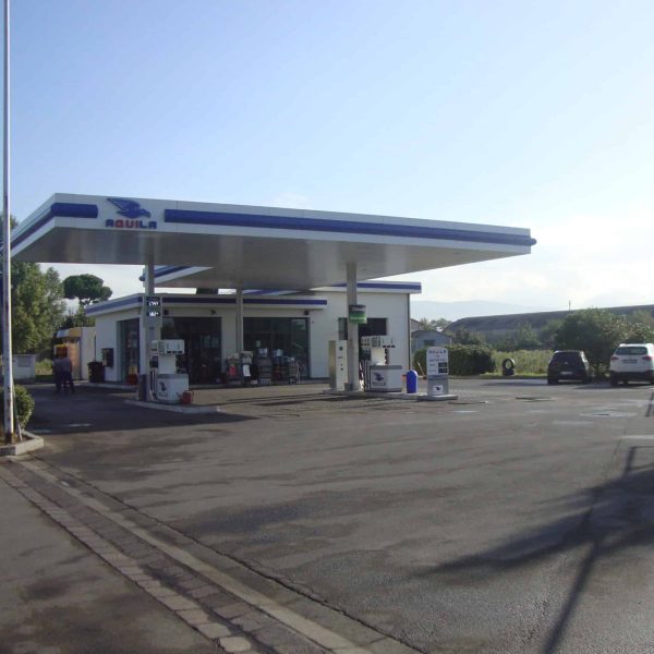 Stazione di servizio con pompe di carburante e area di rifornimento all'aperto.