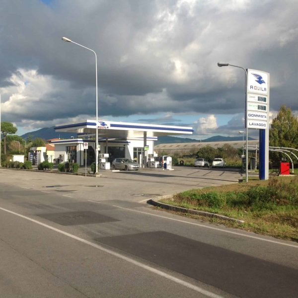 Agenzia di rifornimento carburante Aquila Energie con stazione di servizio moderna e ben illuminata.