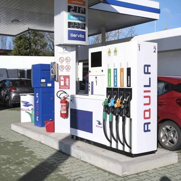 Stazione di rifornimento carburante con distributori e auto in sosta, Aquila Energie.