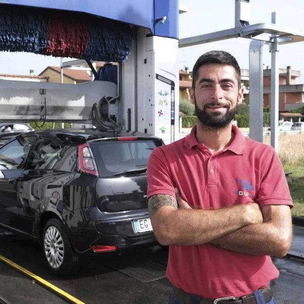 Tecnico di energia rinnovabile davanti a stazione di ricarica auto elettrica.