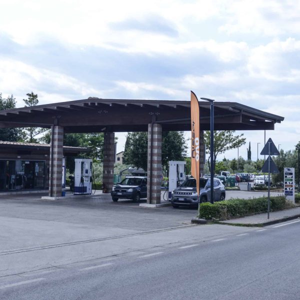 Stazione di rifornimento carburante con pompe e area di servizio all'aperto.